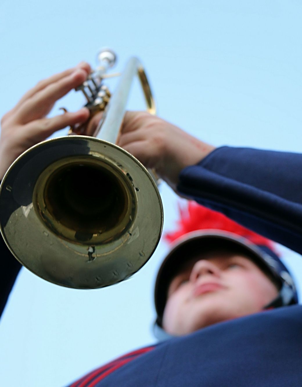 A boy is playing a trumpet in a marching band.