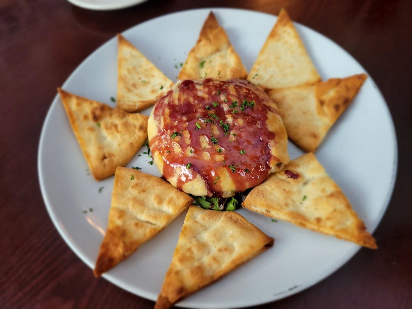 A plate of food that looks like a sun with crackers around it