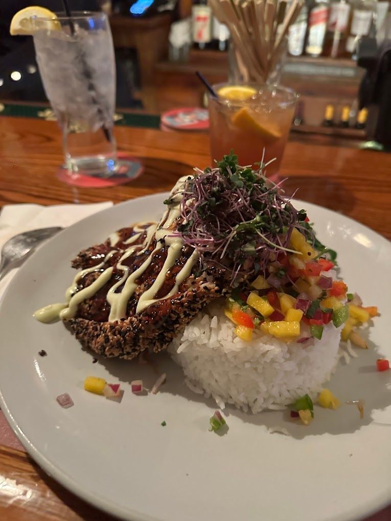 A plate of food with rice and a drink on a table.