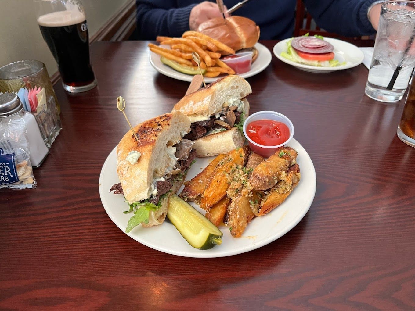 A plate of food with a sandwich and french fries on a table.