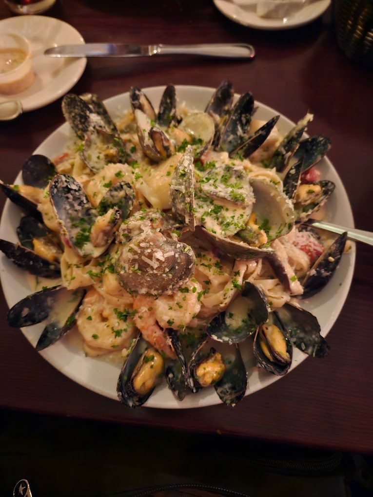 A plate of seafood with a spoon in it on a table.