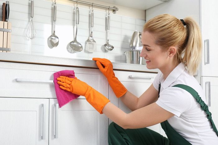 A cleaner wiping the kitchen while on a house cleaning job at Berkshire cleaning