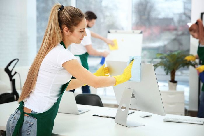 A cleaner cleaning a computer monitor in a commercial cleaning service job from Berkshire  cleaning