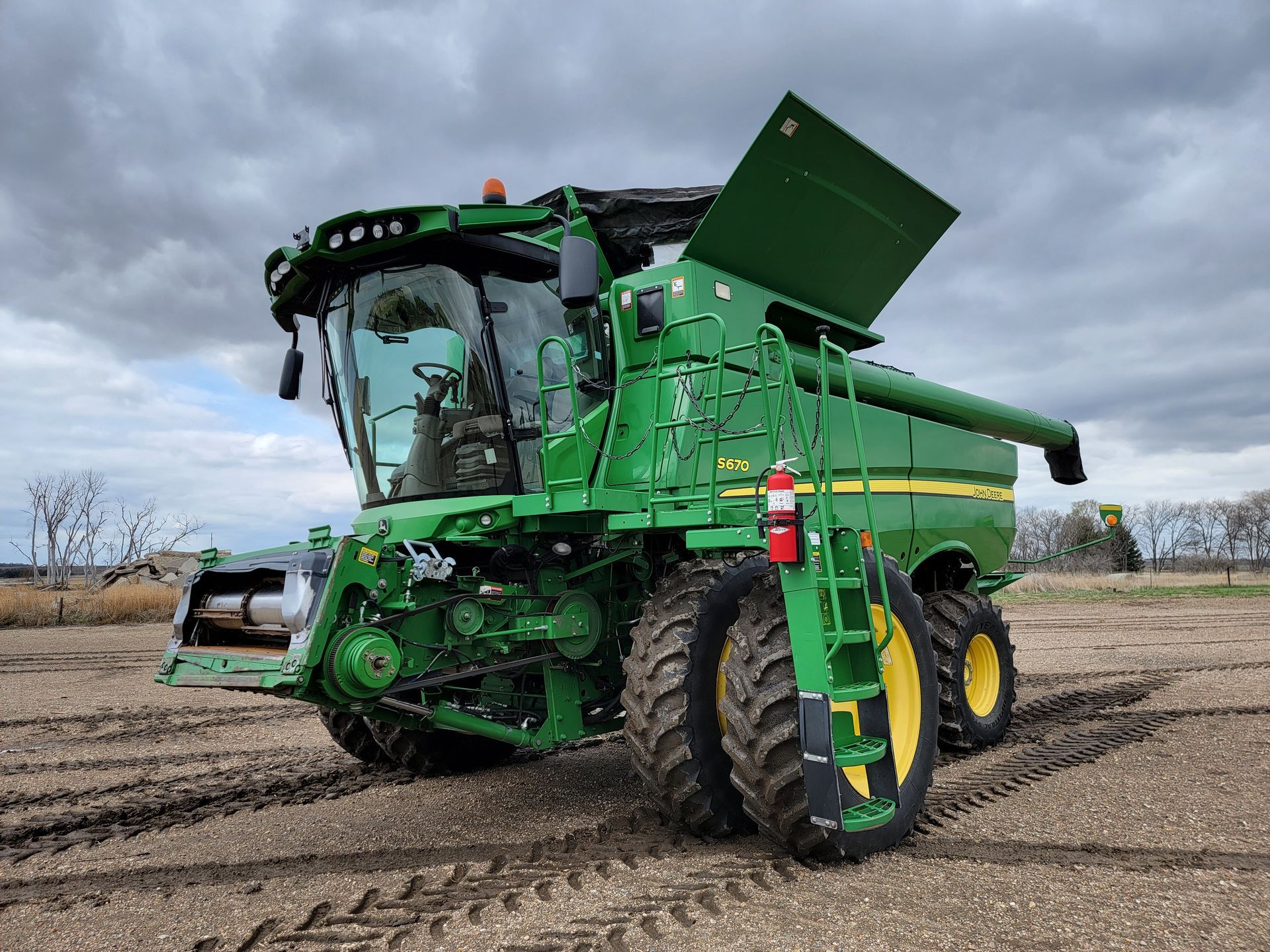 Green John Deere combine harvester in a field.