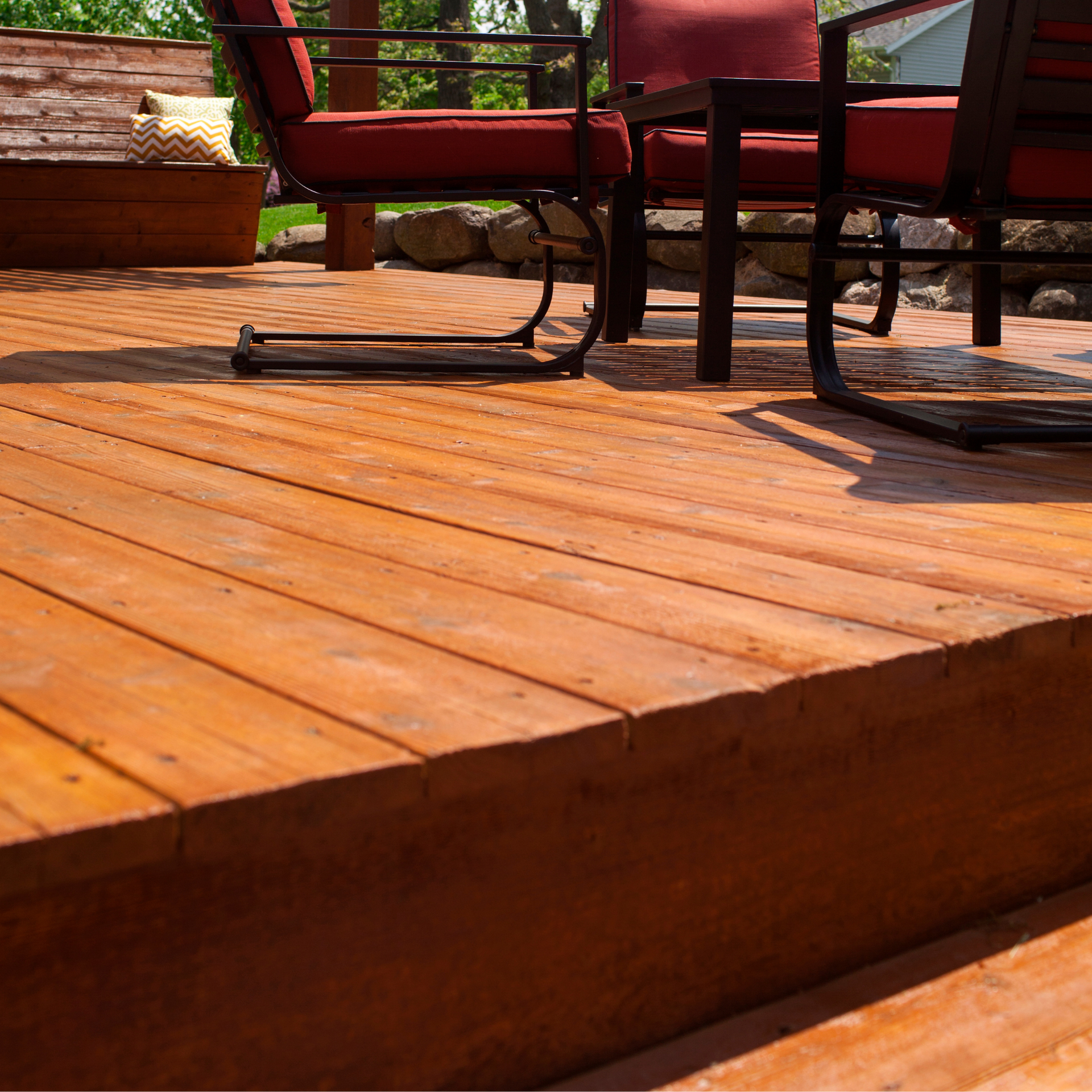 A stained deck with a table and chairs on it