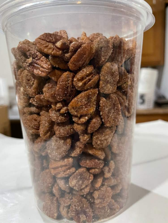 Clear plastic container filled with sugared pecans.
