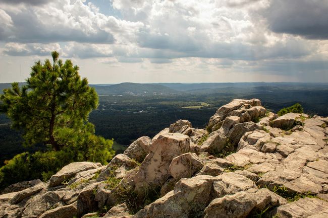 A view of a city from the top of a rocky mountain.