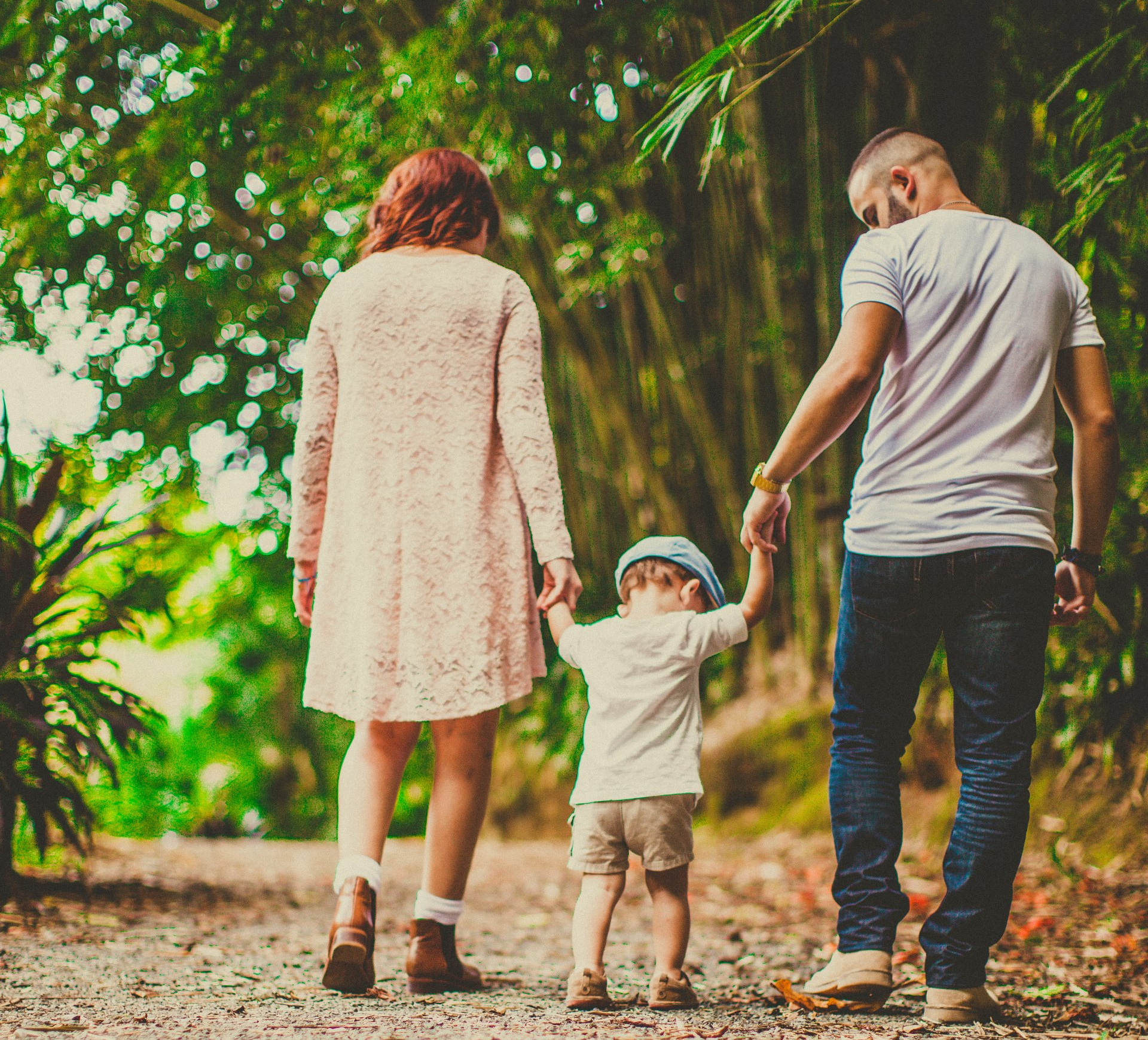 A man and woman are walking down a road with a child.