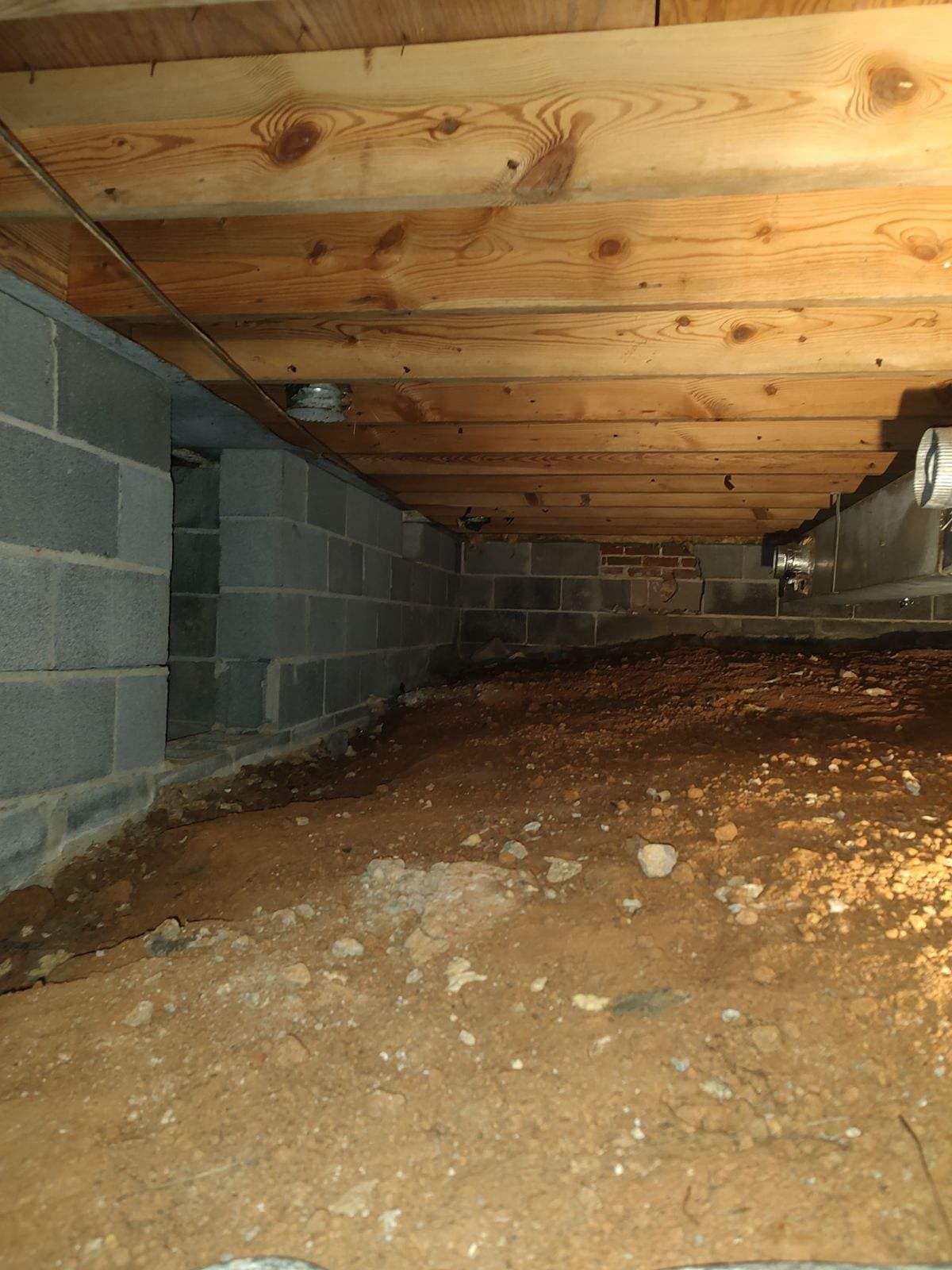 A basement with a wooden ceiling and brick walls.