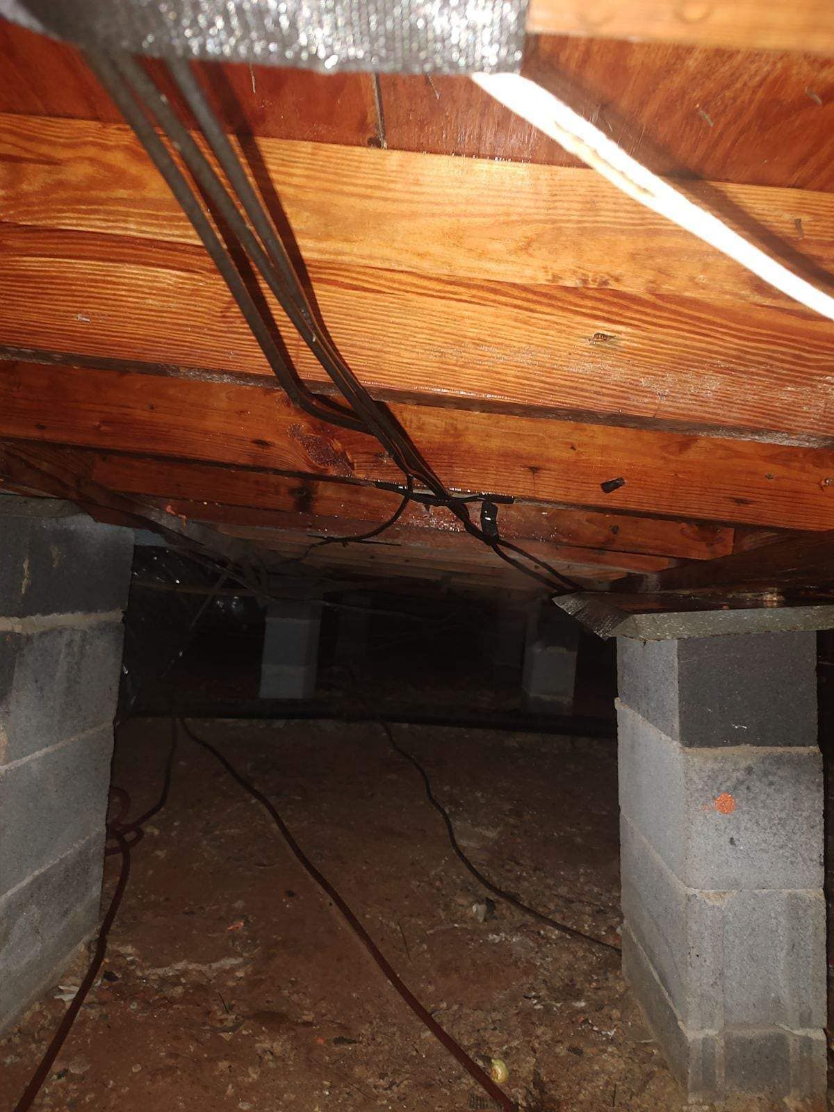 A basement with a wooden ceiling and a lot of wires coming out of it.