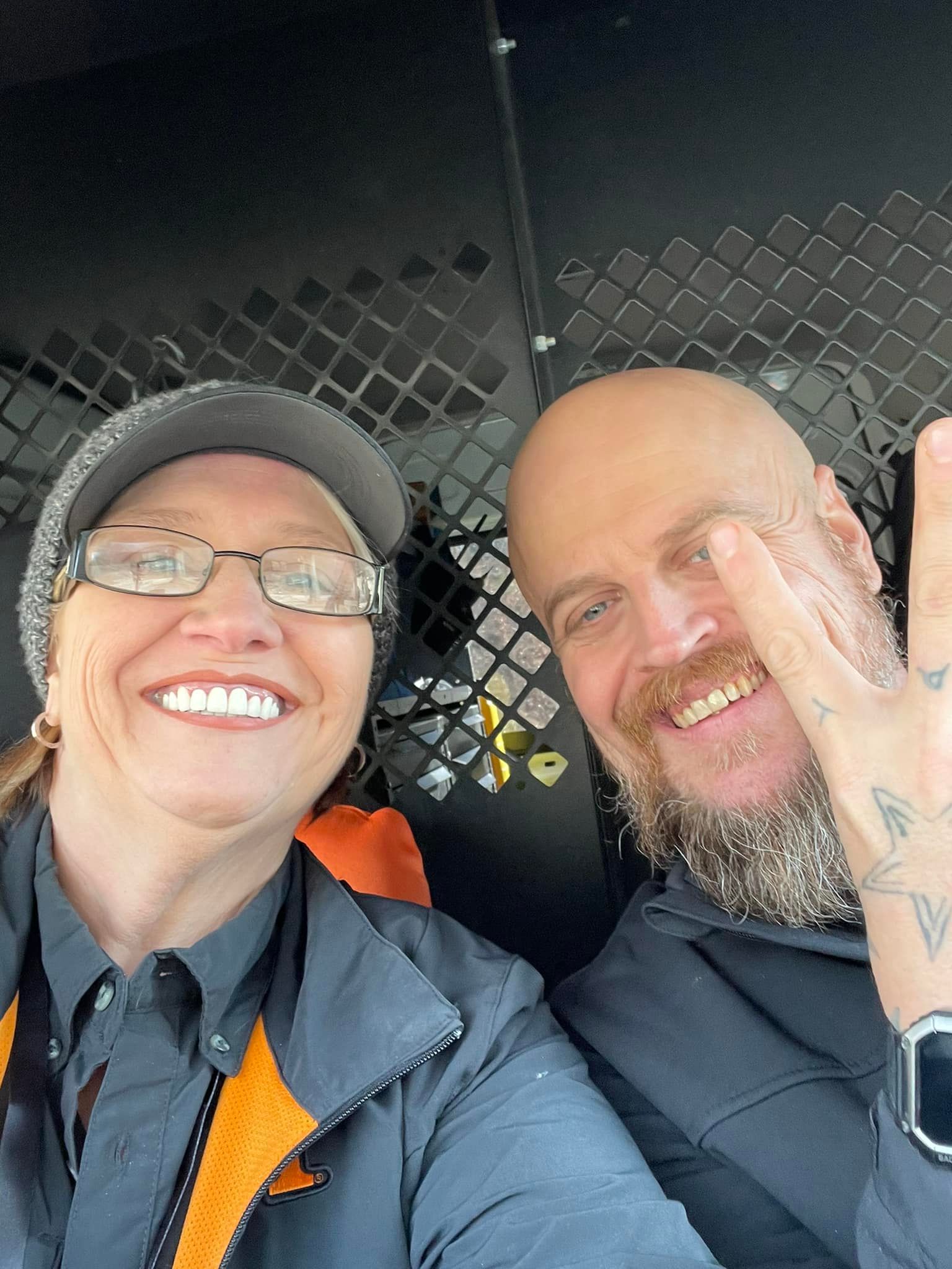 A man and a woman are posing for a picture in a van.