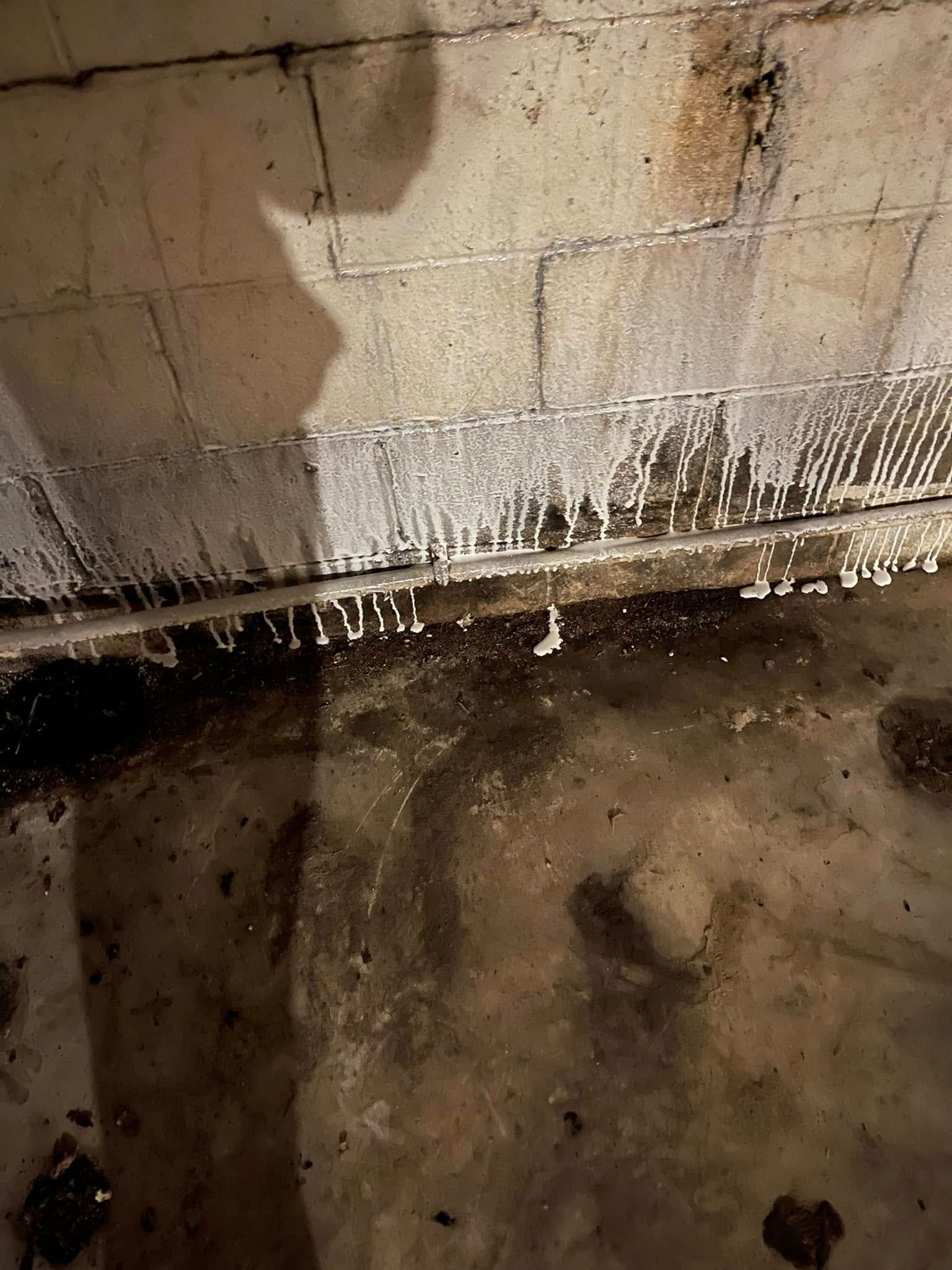 A dirty basement with a lot of water coming out of it.