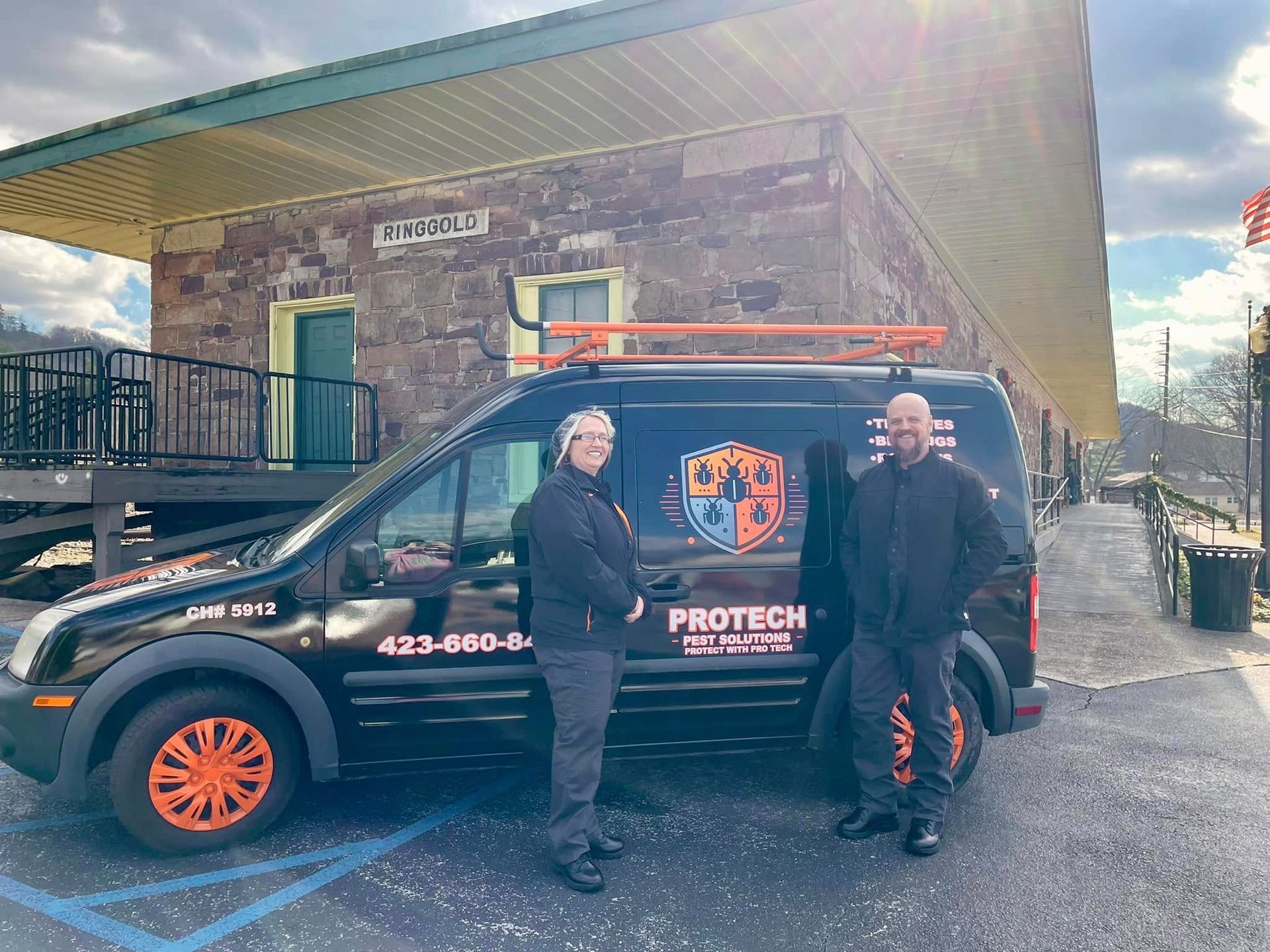 Two men are standing in front of a protech van.