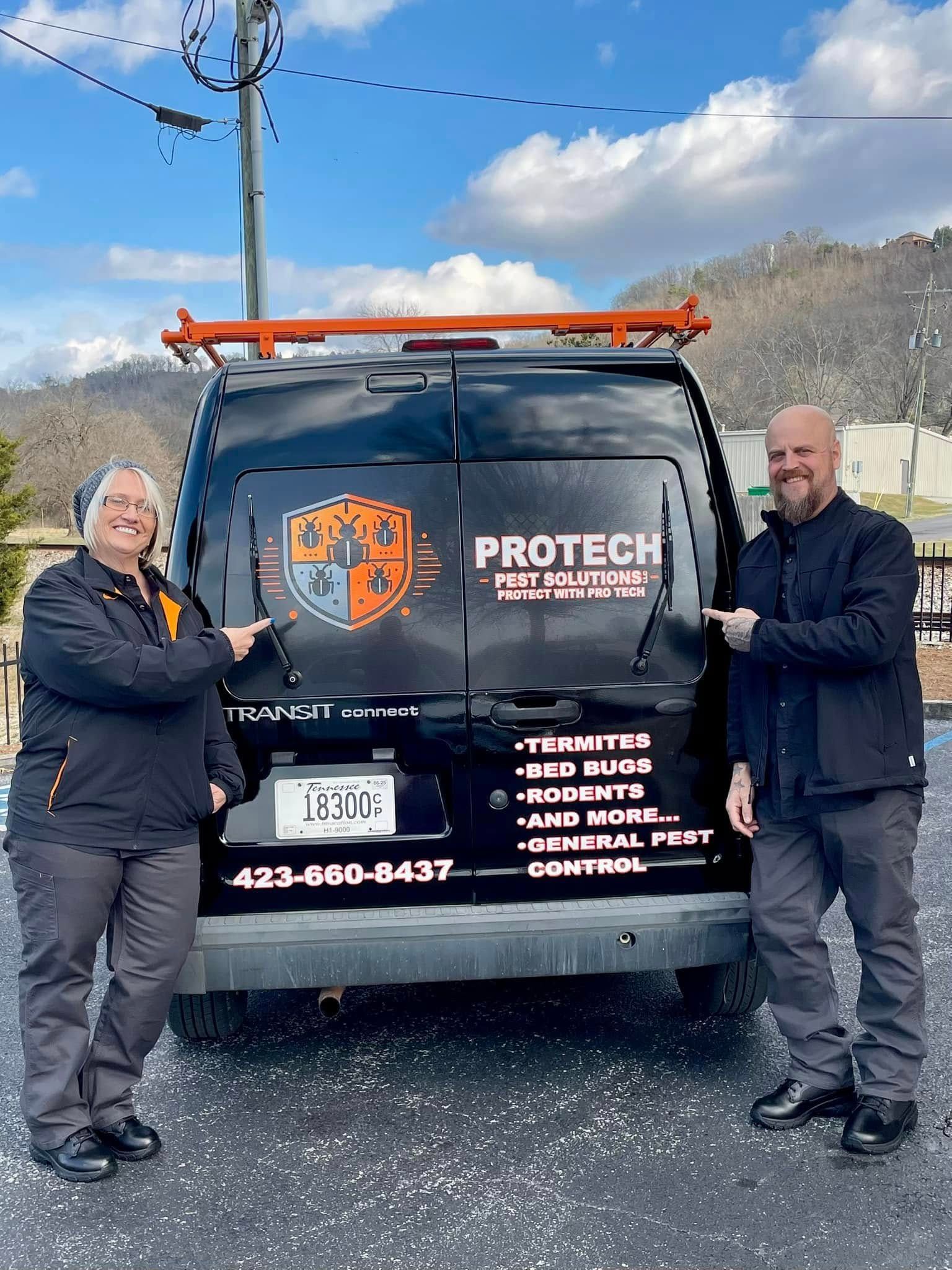 Two men are standing in front of a van.