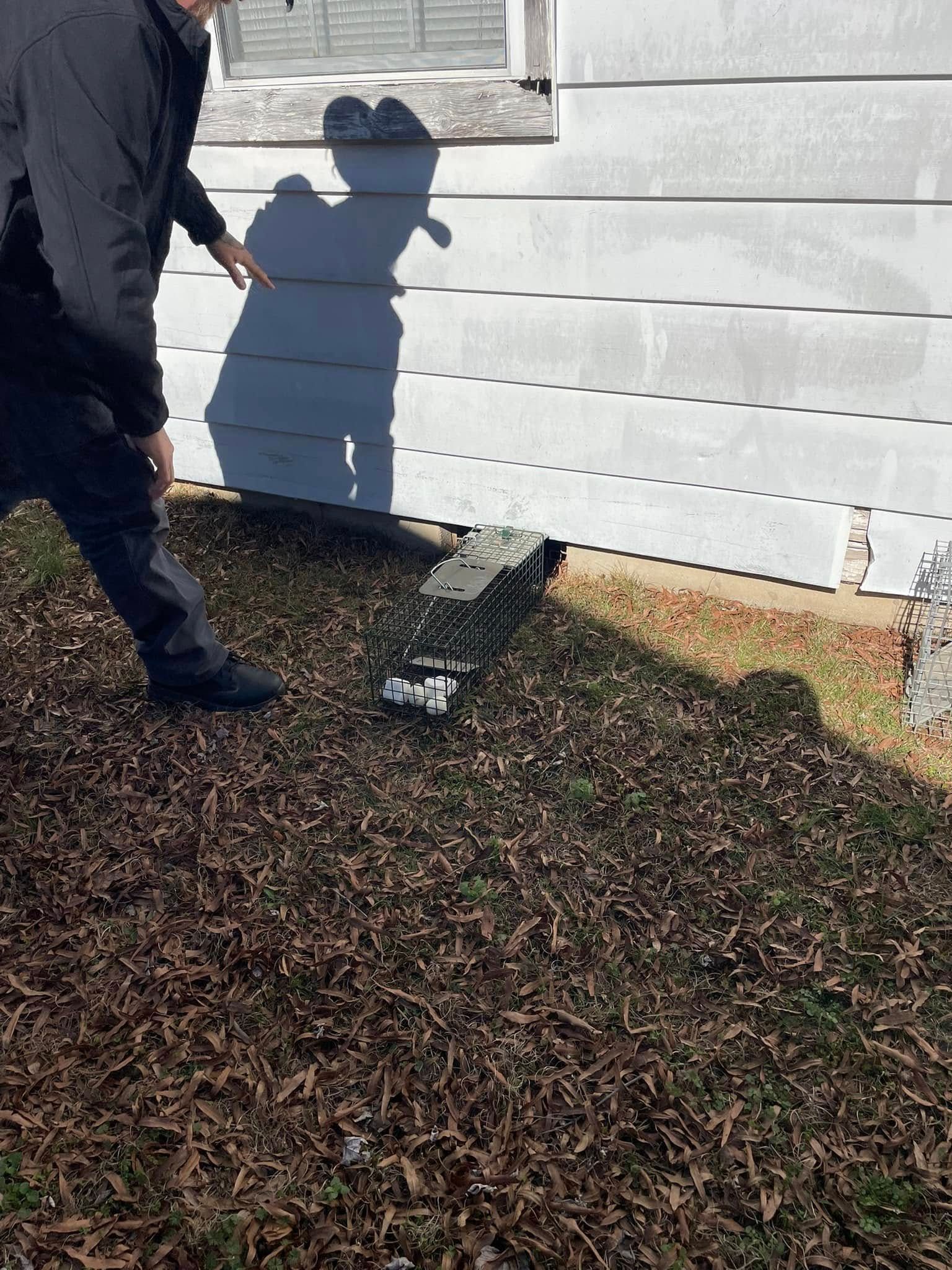 A man is standing in front of a white house.