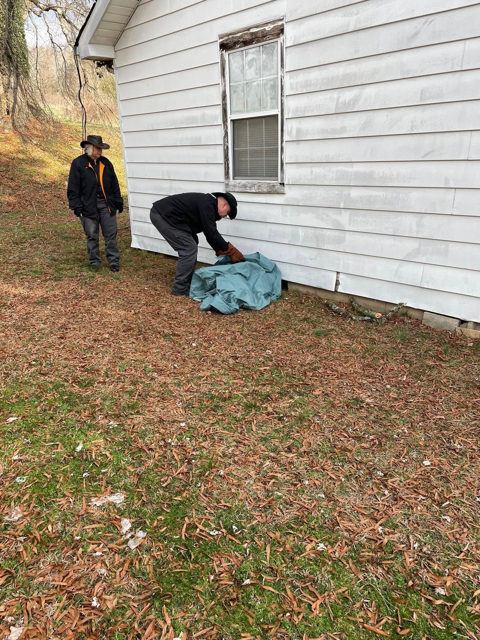 Two men are standing in front of a white house.