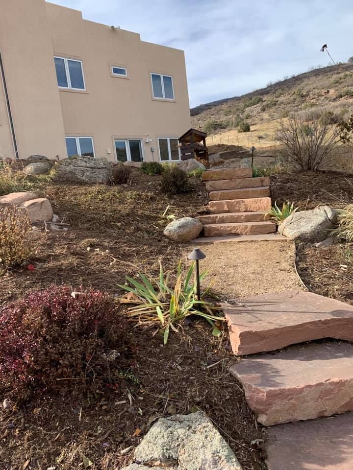 A house is sitting on top of a hill with stairs leading up to it.