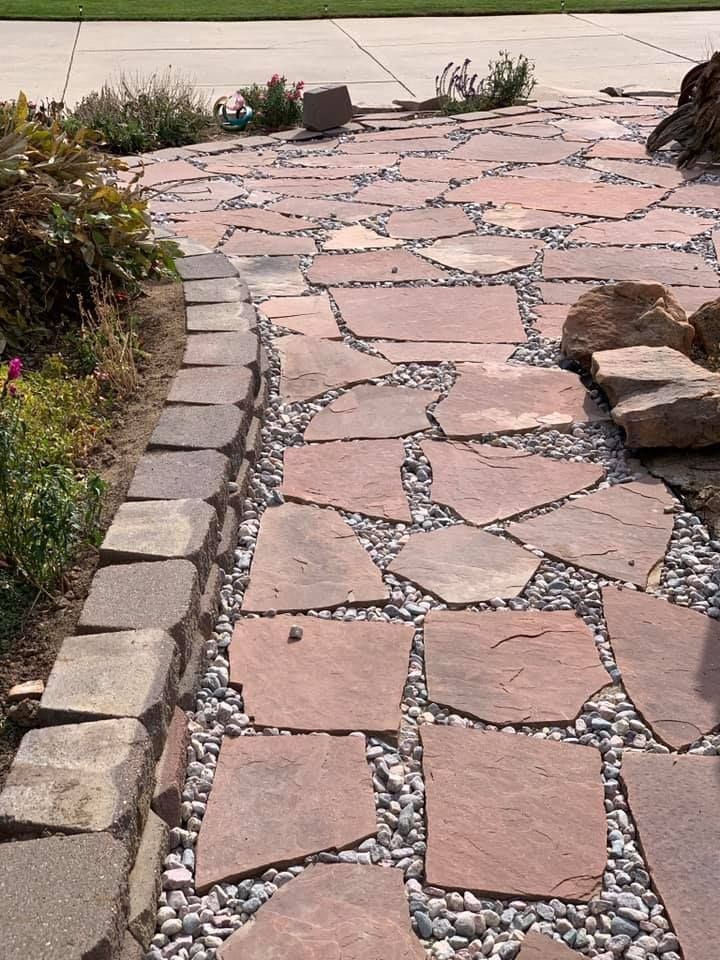 A stone walkway with rocks and gravel along the side of it