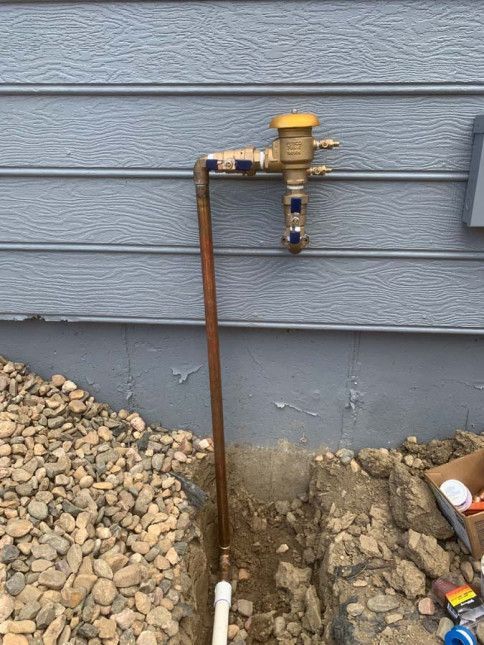 A copper pipe is being installed on the side of a house.
