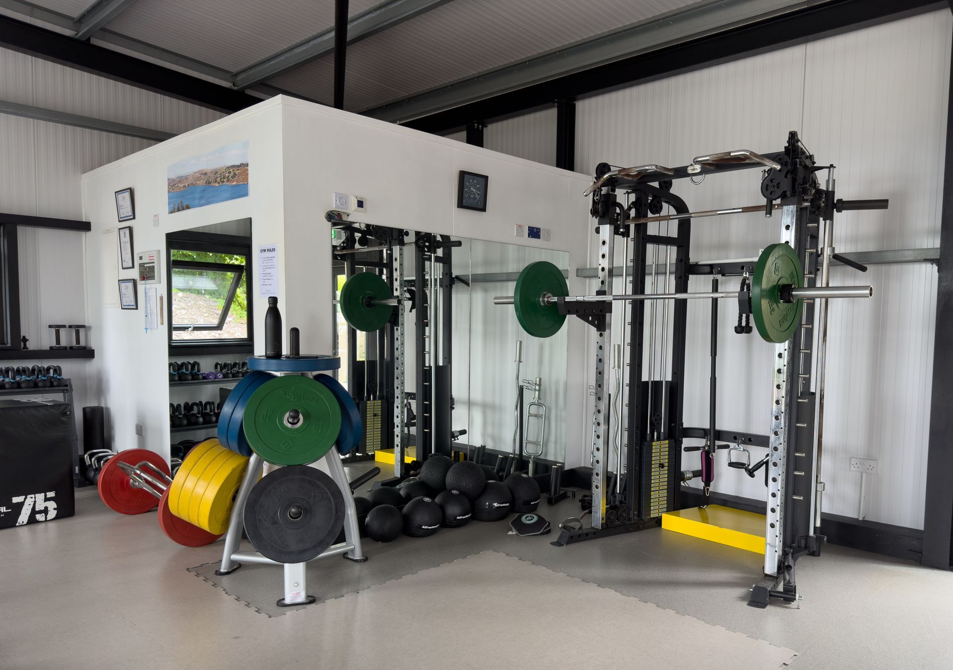 Weightlifting gym with barbell, weights, and rack.