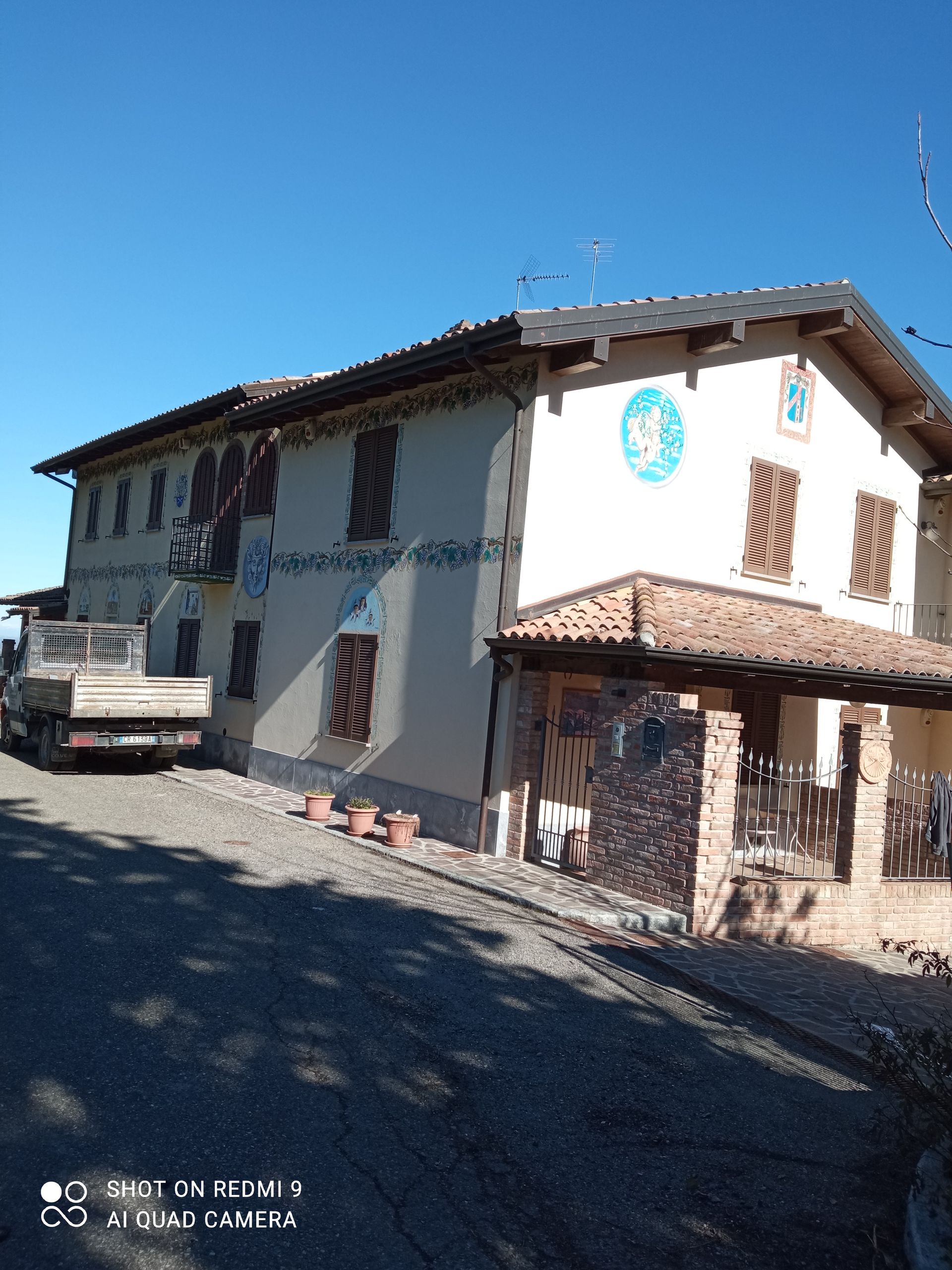 Un grande edificio bianco con un camion parcheggiato di fronte.