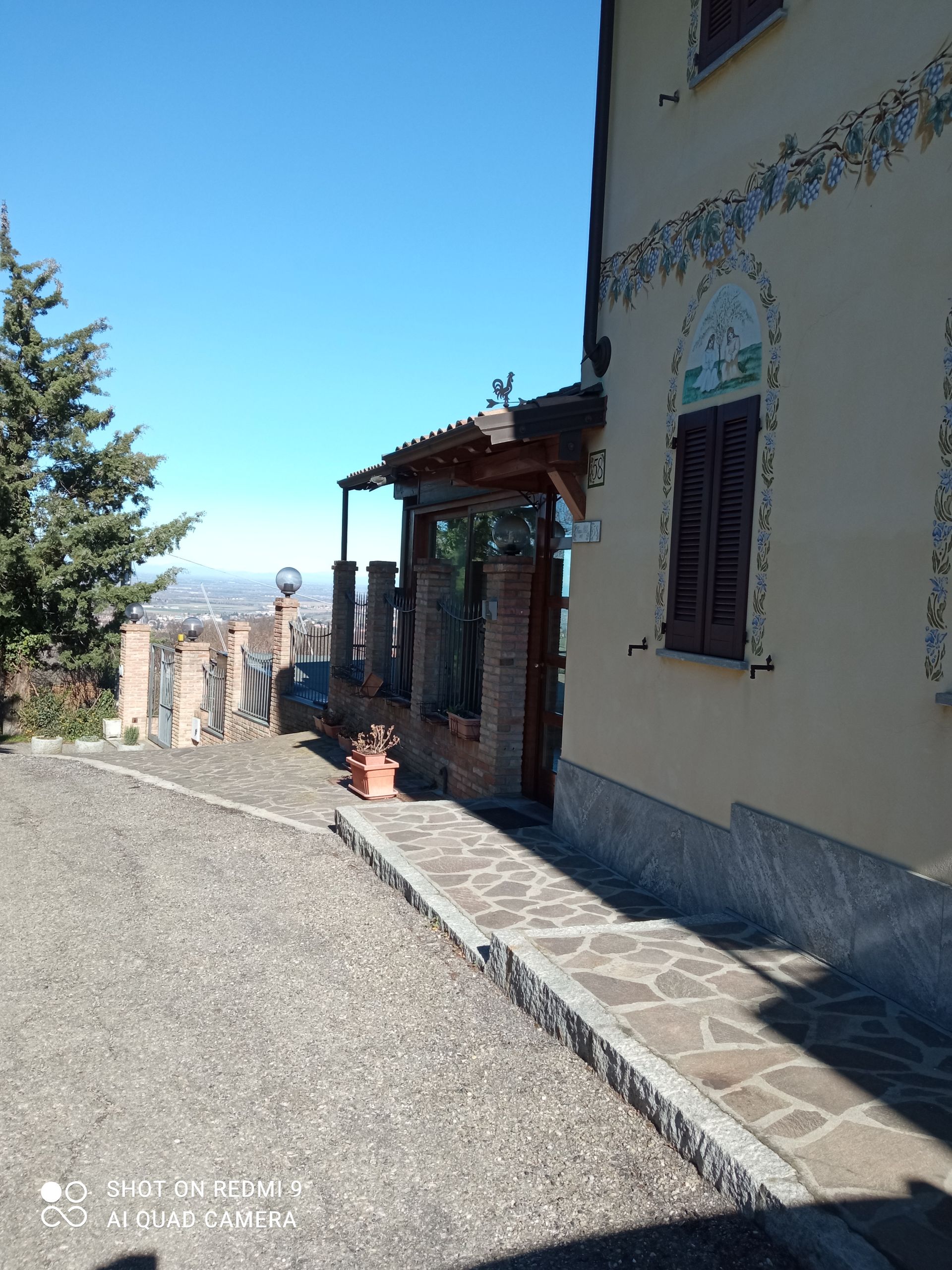 Una casa con un sentiero in pietra che vi conduce e un cielo azzurro sullo sfondo.