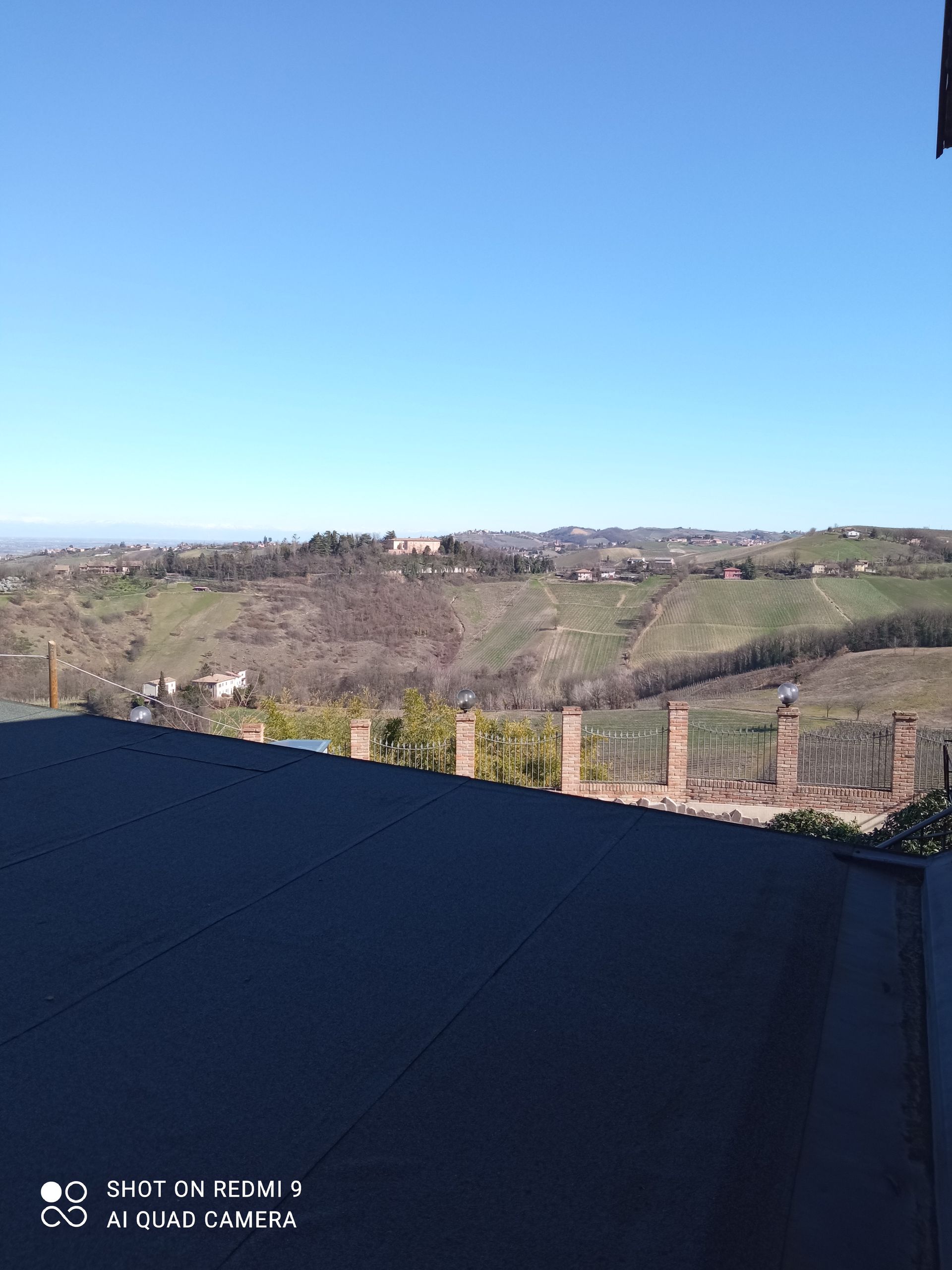 Una vista di una valle da un balcone in una giornata di sole.