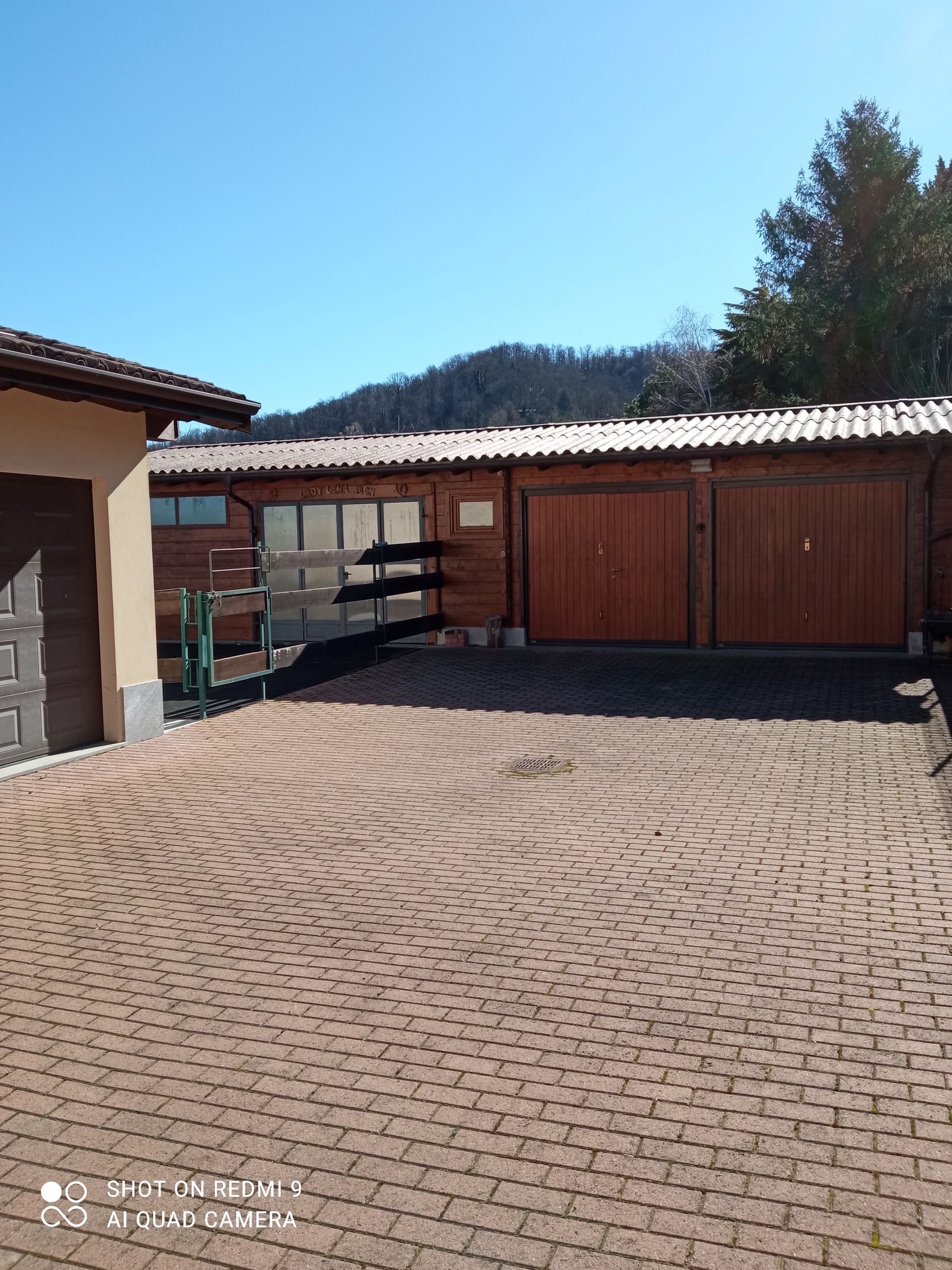 Un vialetto in mattoni che conduce a un garage e a un edificio.