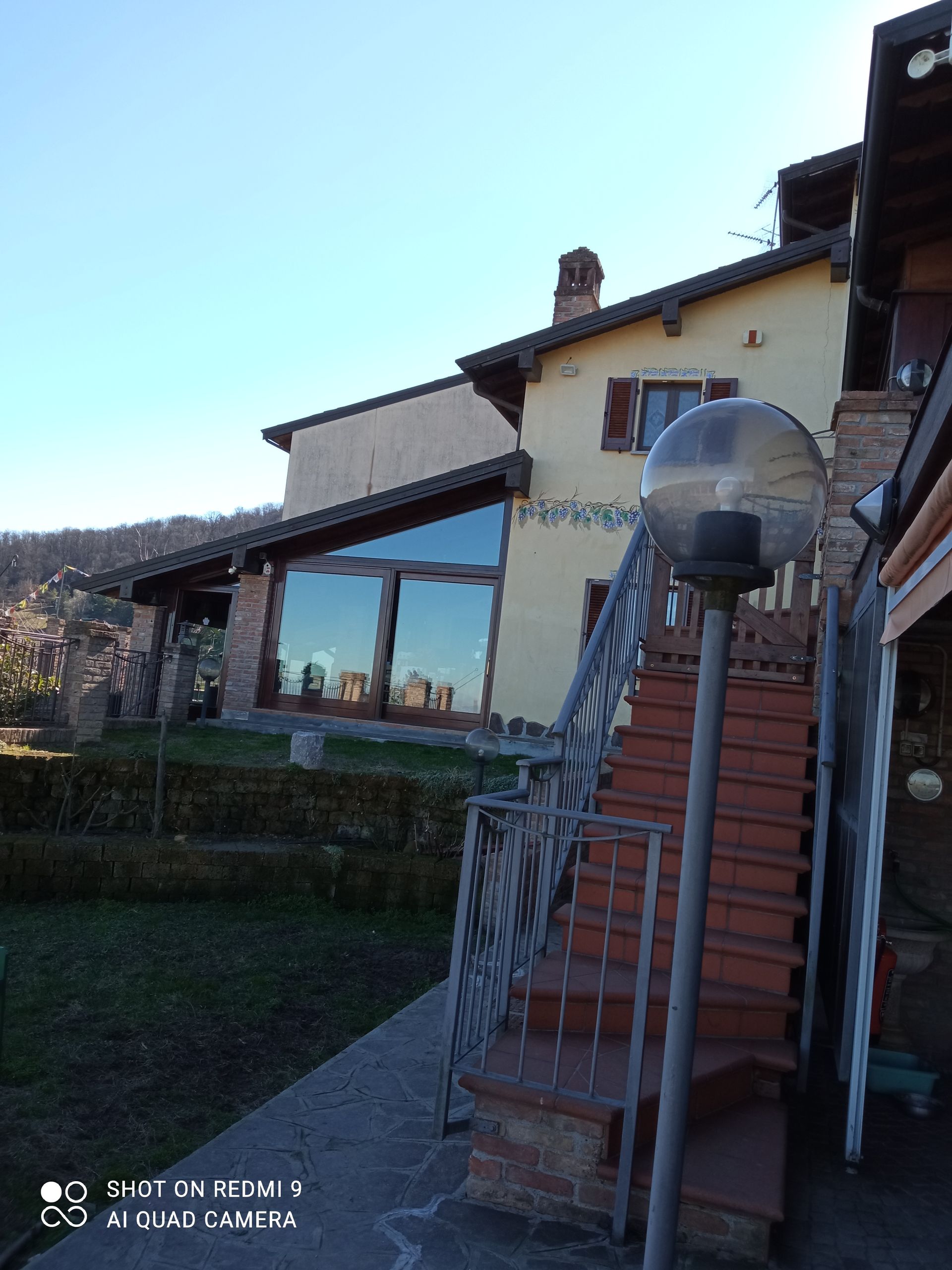 Una casa con delle scale che vi portano e un lampione di fronte.