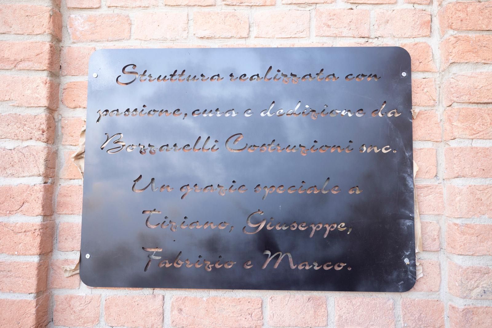 A sign on a brick wall says