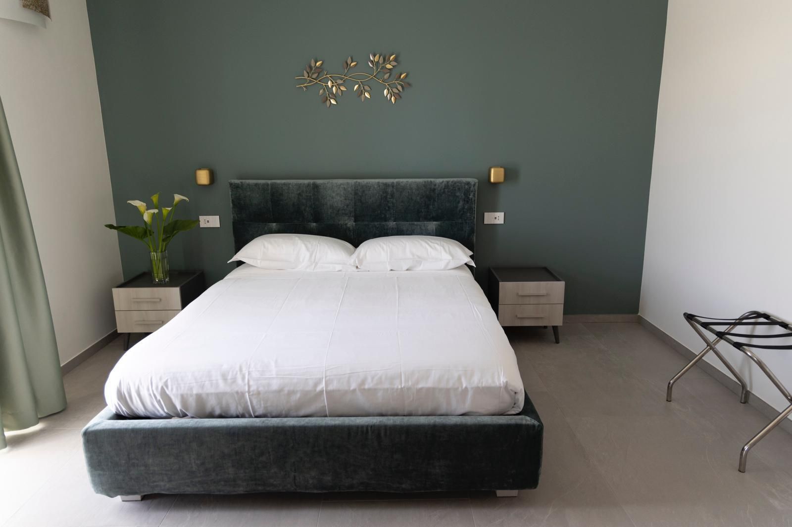 Una camera da letto con un letto grande e una parete verde