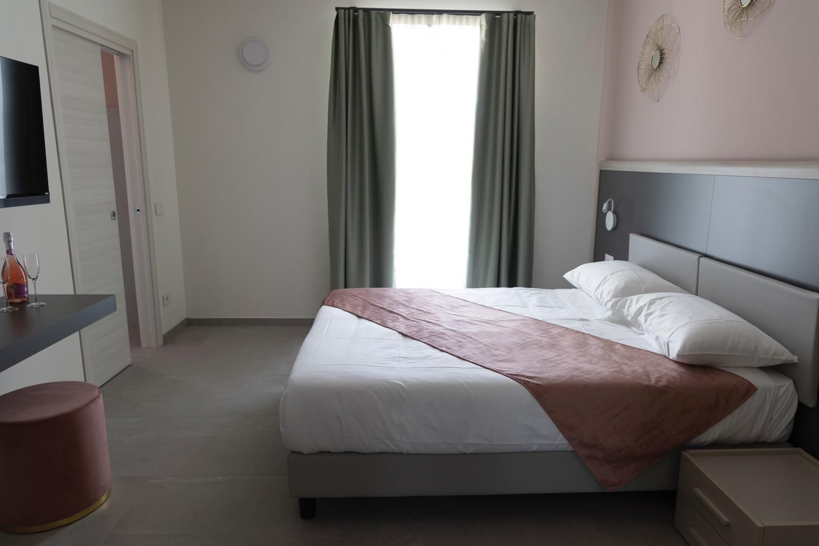 Una camera d'albergo con un letto grande e una televisione.