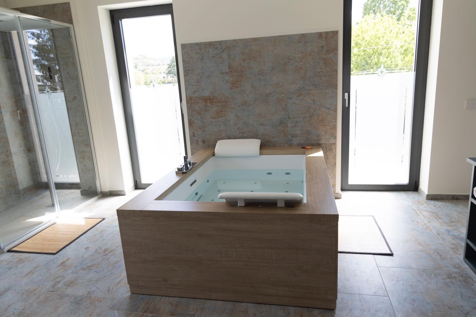 Un bagno con vasca idromassaggio e ampia finestra