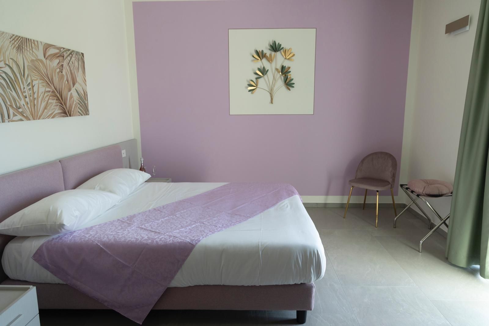 Una camera da letto con pareti viola e un letto viola