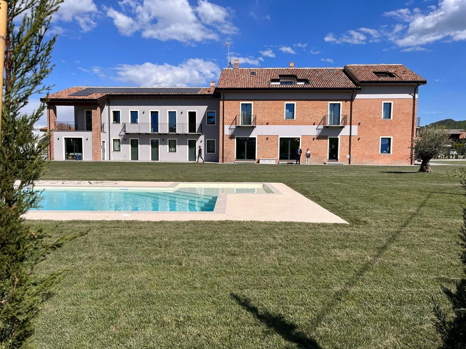 Una grande casa con una piscina di fronte.