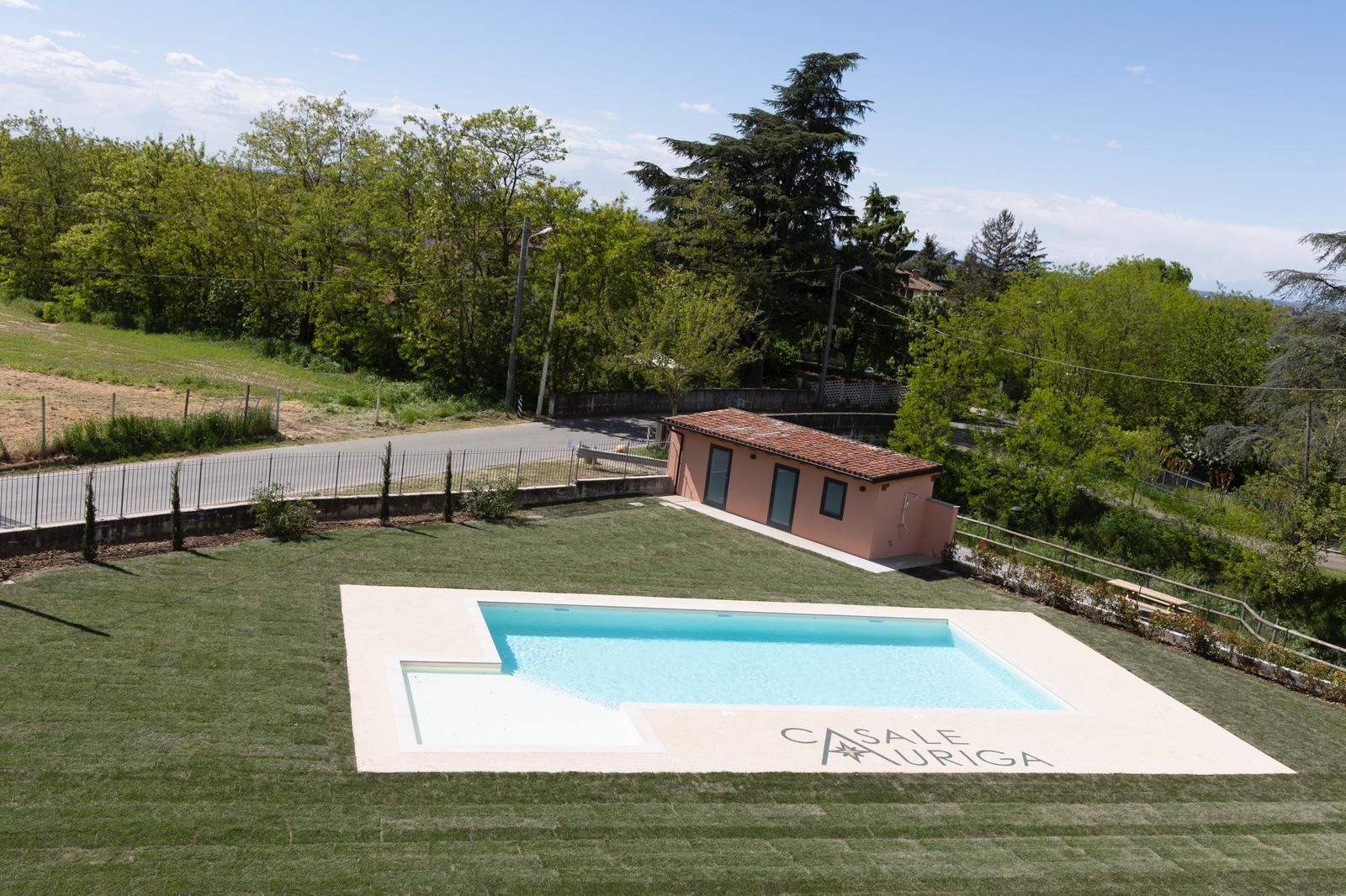 C'è una grande piscina in mezzo a un rigoglioso campo verde.
