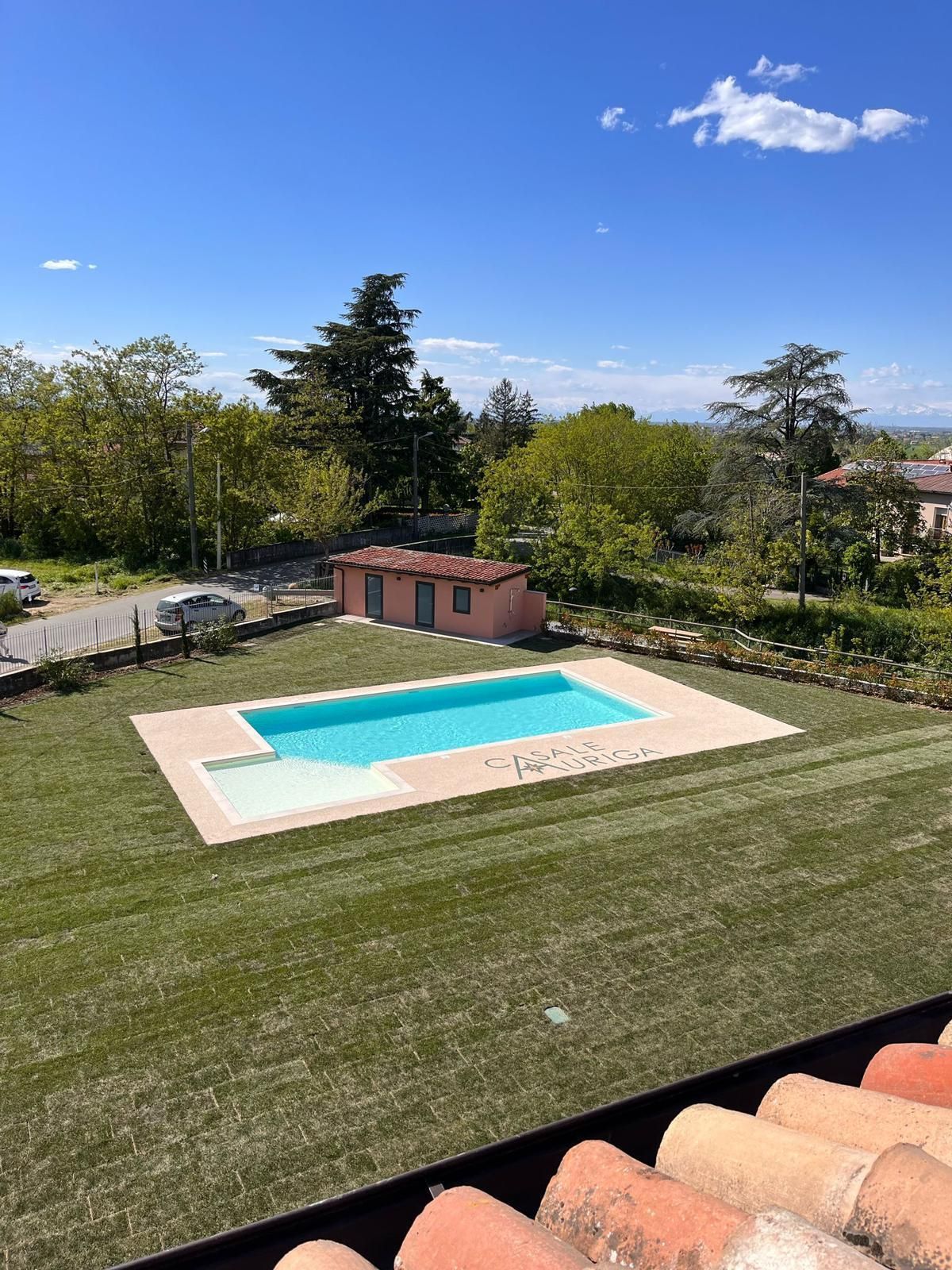 C'è una grande piscina in mezzo a un rigoglioso campo verde.
