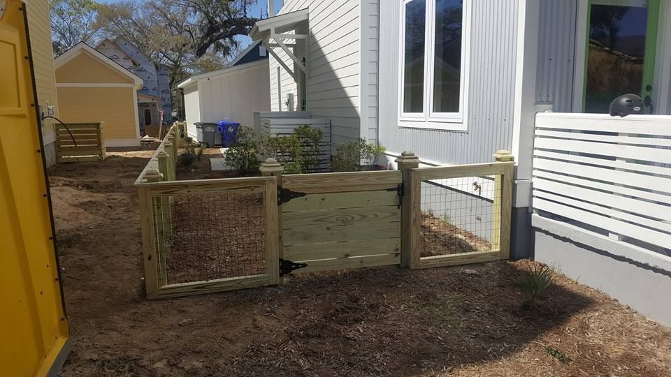 A small wooden fence is in front of a house.