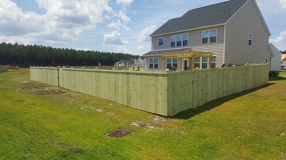 A large house with a wooden fence in front of it.