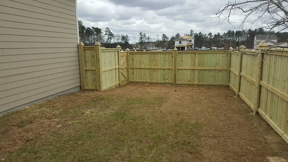 There is a wooden fence in the backyard of a house.