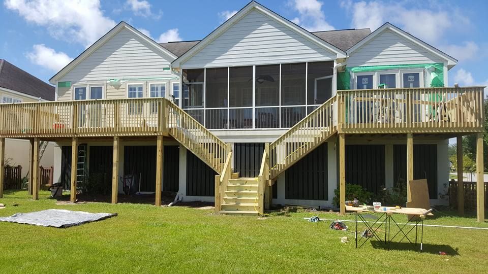 A house with a screened in porch and a large wooden deck