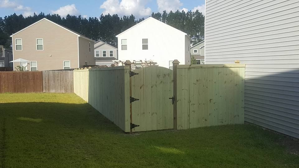 A wooden fence with a gate in the backyard of a house