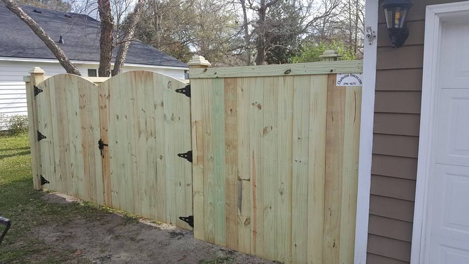 A wooden fence with a gate in the backyard of a house.