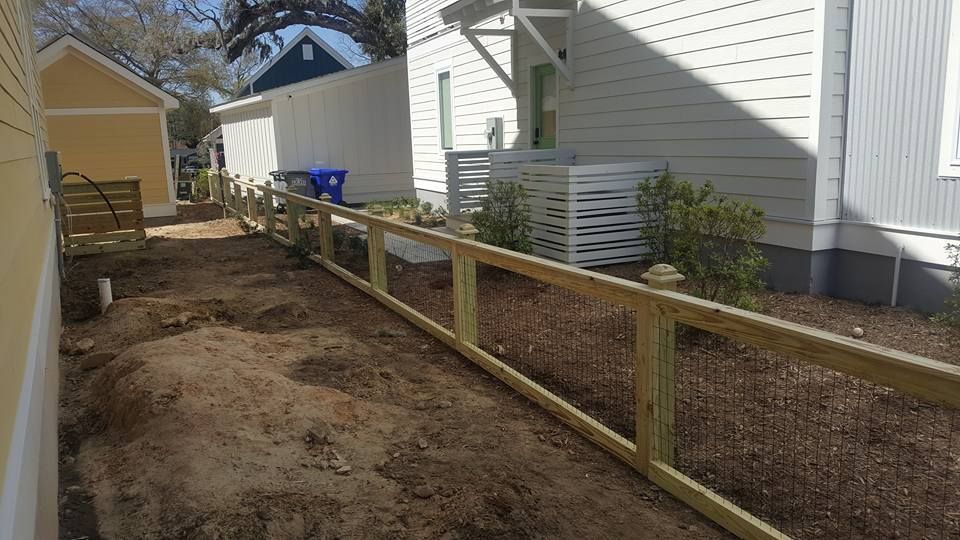 A wooden fence is being built in front of a house.