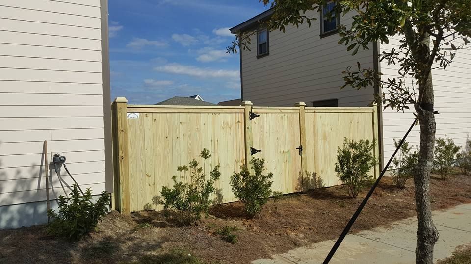 A wooden fence is in front of a house