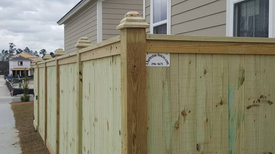 A wooden fence is sitting in front of a house.
