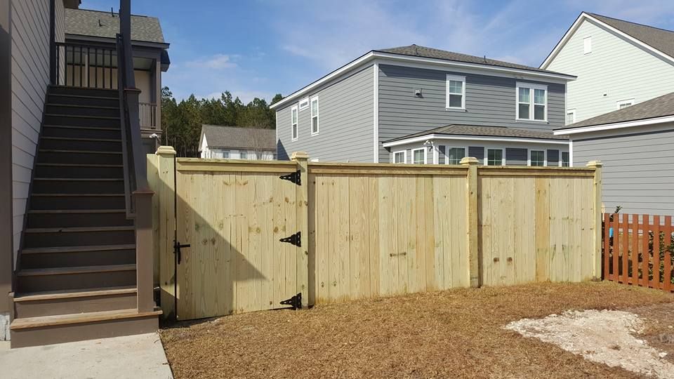 A wooden fence with a gate in the backyard of a house.