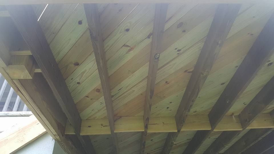 The ceiling of a wooden deck is being built.