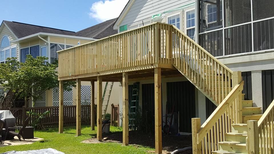 A house with a screened in porch and a wooden deck