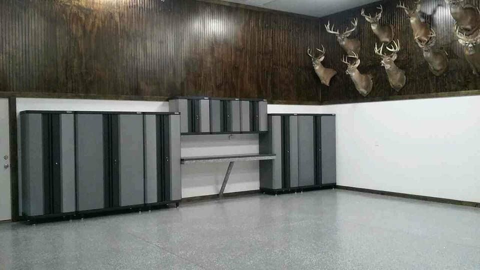 A garage with a lot of cabinets and deer heads on the wall.